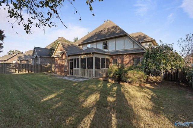 back of property with a patio, a lawn, and a sunroom