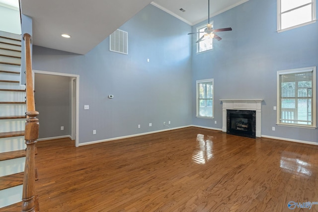 unfurnished living room with ceiling fan, high vaulted ceiling, ornamental molding, and hardwood / wood-style floors