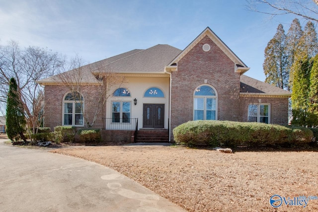 view of front of home with covered porch and brick siding