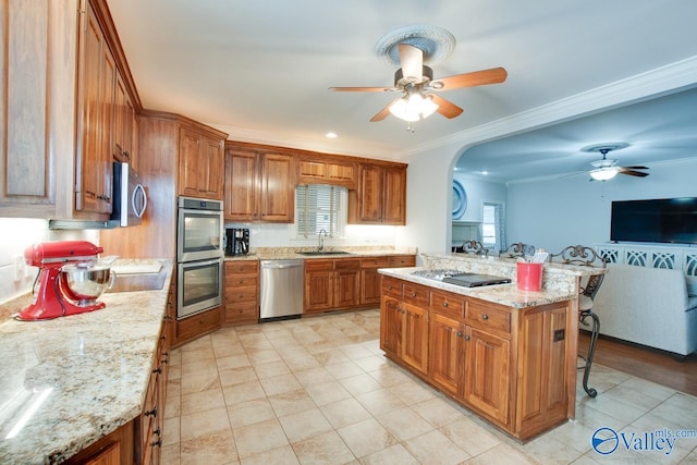 kitchen with stainless steel appliances, brown cabinetry, and a sink