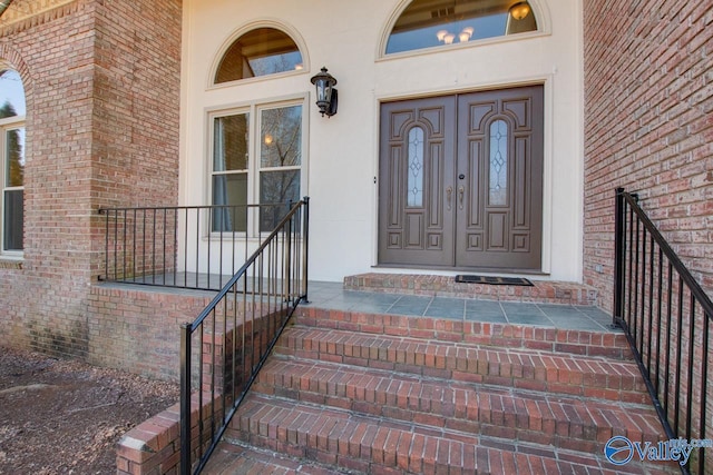 doorway to property with brick siding and a porch