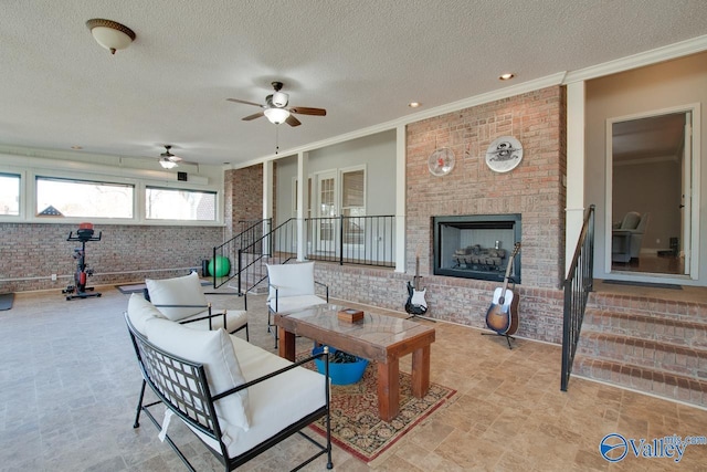 living area featuring ornamental molding, a brick fireplace, stairway, and brick wall