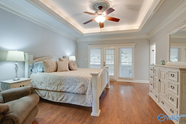 bedroom featuring access to outside, crown molding, a tray ceiling, and wood finished floors