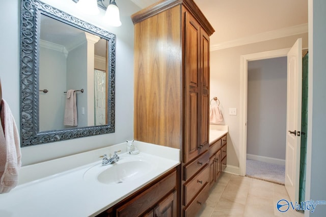 bathroom with tile patterned flooring, ornamental molding, baseboards, and vanity