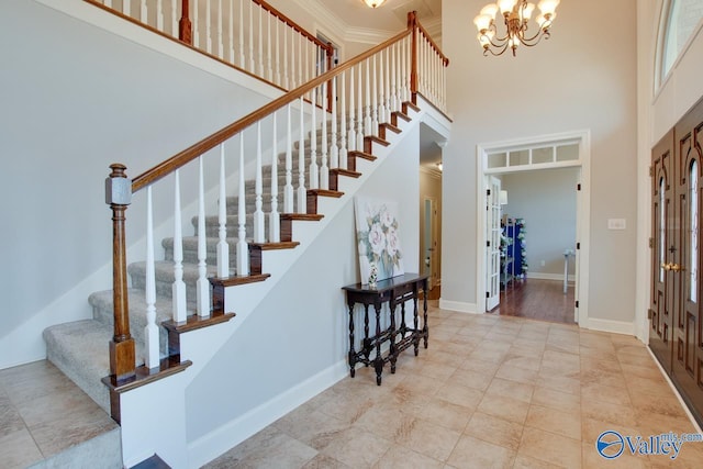 foyer entrance with a towering ceiling, stairs, baseboards, and a chandelier