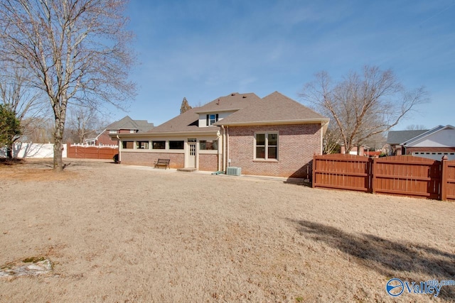 back of house with central AC unit, fence, and brick siding