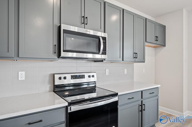 kitchen featuring stainless steel appliances, gray cabinets, and hardwood / wood-style flooring