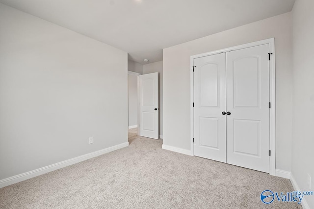 unfurnished bedroom with light carpet and a closet