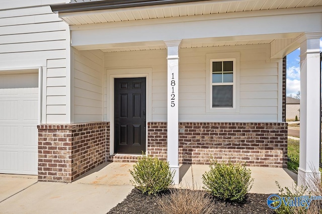 property entrance featuring covered porch and a garage