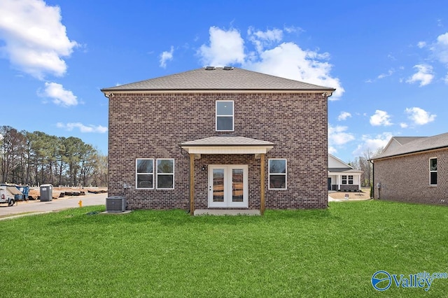 rear view of property with a yard, cooling unit, and french doors