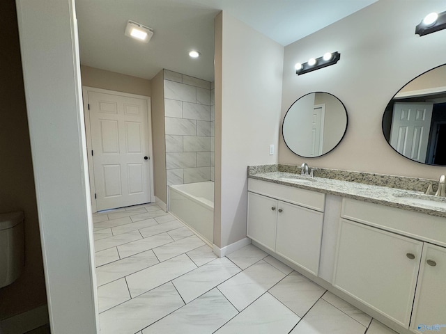 bathroom with tiled shower / bath, tile patterned floors, and vanity