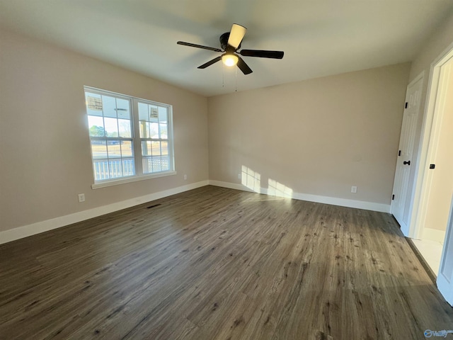 empty room with ceiling fan and dark hardwood / wood-style flooring