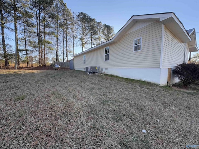 view of home's exterior with cooling unit and a lawn