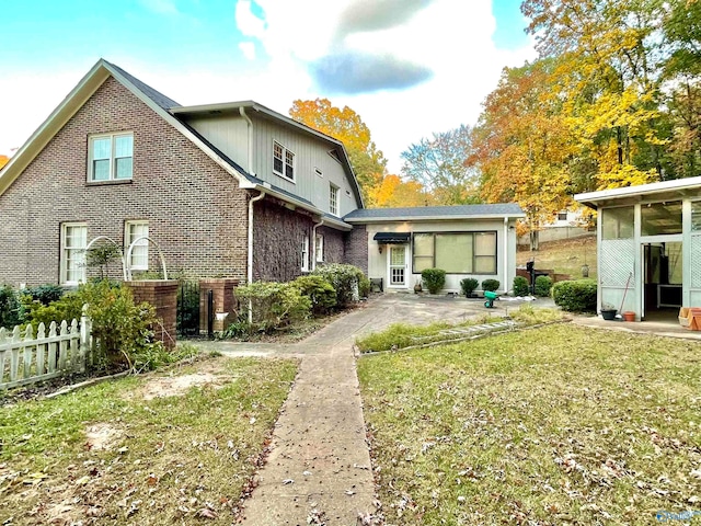 back of house with a sunroom and a yard