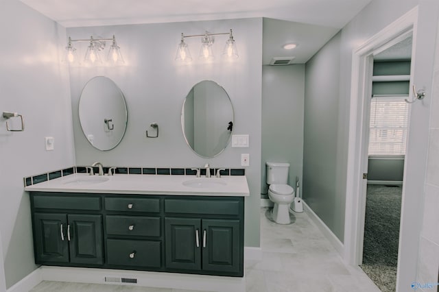 bathroom with double vanity, visible vents, and a sink