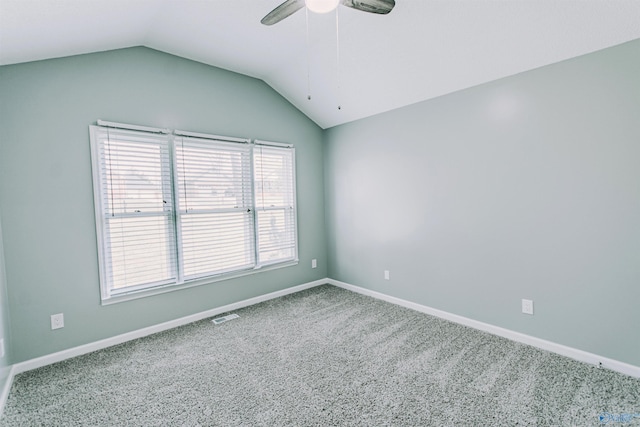 carpeted empty room with ceiling fan, baseboards, vaulted ceiling, and visible vents
