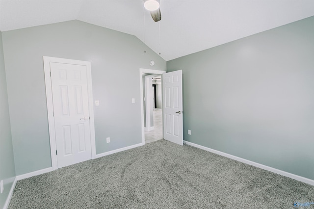unfurnished bedroom with carpet, baseboards, vaulted ceiling, and ceiling fan