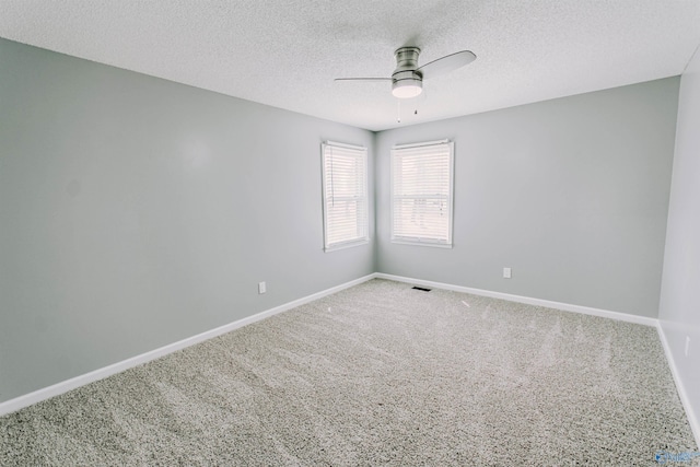 carpeted spare room with baseboards, a ceiling fan, and a textured ceiling
