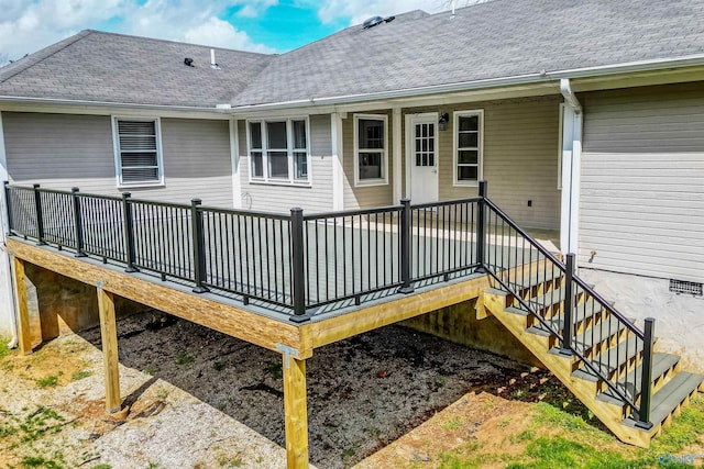 rear view of house featuring a deck and a shingled roof