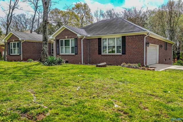 single story home with a front yard, brick siding, driveway, and an attached garage