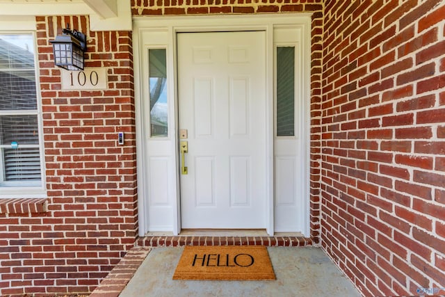 doorway to property featuring brick siding
