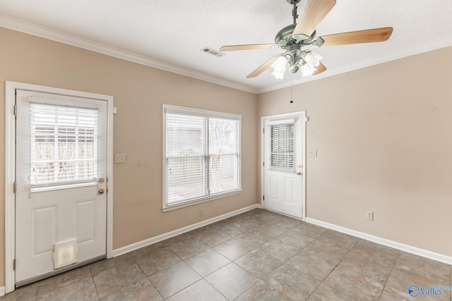 doorway with a textured ceiling, ornamental molding, and ceiling fan