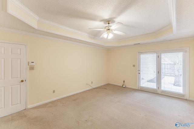 carpeted spare room featuring ceiling fan, crown molding, a raised ceiling, and a textured ceiling