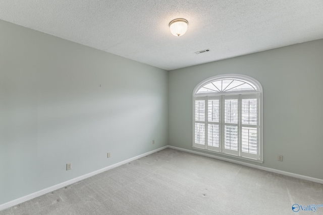 carpeted spare room featuring a textured ceiling