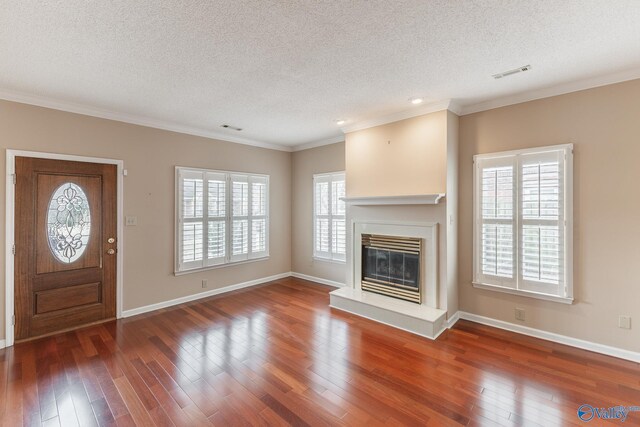 unfurnished living room with a wealth of natural light, ornamental molding, and dark hardwood / wood-style floors