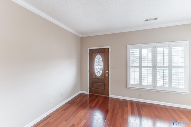 entrance foyer with crown molding, a textured ceiling, and dark hardwood / wood-style flooring