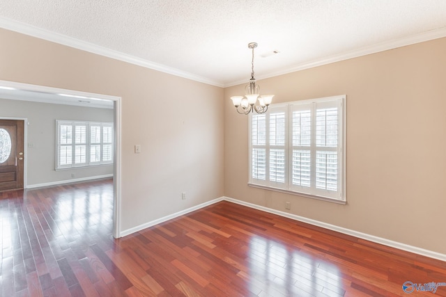 spare room with ornamental molding, a chandelier, a textured ceiling, and dark hardwood / wood-style flooring
