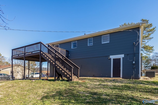 rear view of property with a deck, central AC unit, and a lawn