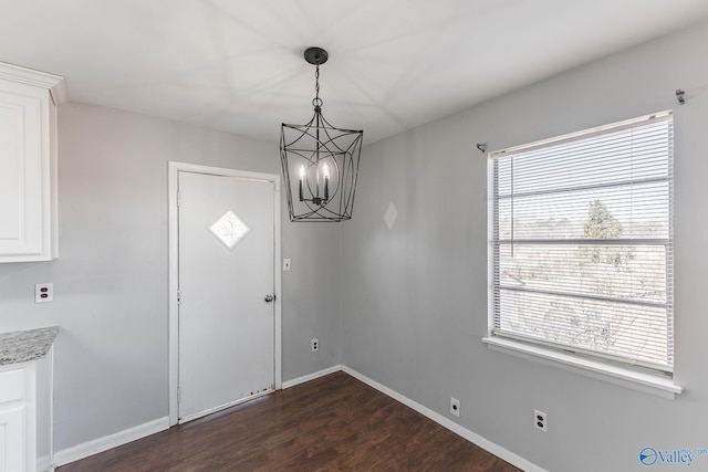 entrance foyer featuring dark hardwood / wood-style floors and a notable chandelier