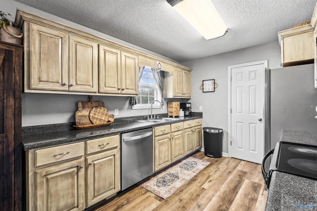 kitchen with stainless steel appliances, light hardwood / wood-style floors, sink, and a textured ceiling