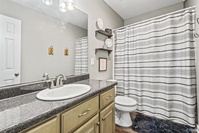 bathroom with vanity, a textured ceiling, a shower with curtain, and toilet