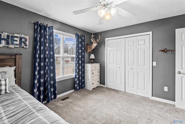 bedroom featuring ceiling fan, carpet flooring, a textured ceiling, and a closet