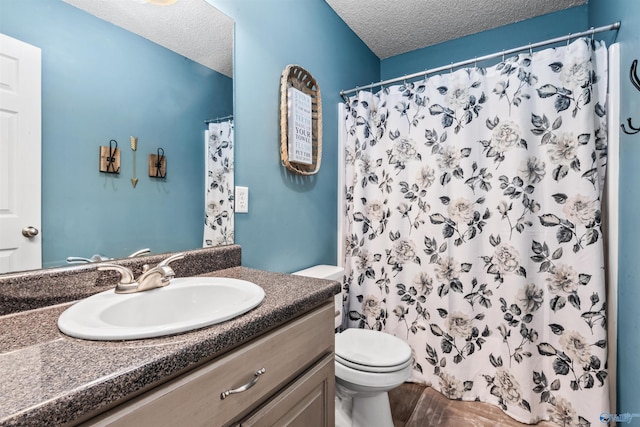 bathroom with vanity, toilet, a shower with shower curtain, and a textured ceiling