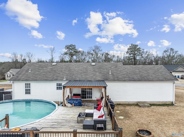 rear view of property with a pool side deck and outdoor lounge area