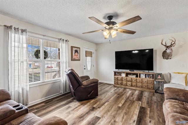 living room with hardwood / wood-style floors, a textured ceiling, and ceiling fan