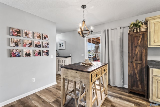 dining area featuring dark hardwood / wood-style floors, a chandelier, and a textured ceiling