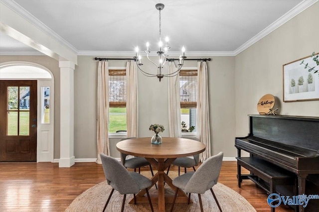 dining space featuring ornamental molding, dark wood-type flooring, and a notable chandelier