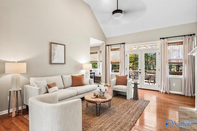 living room with ceiling fan, wood-type flooring, high vaulted ceiling, and french doors