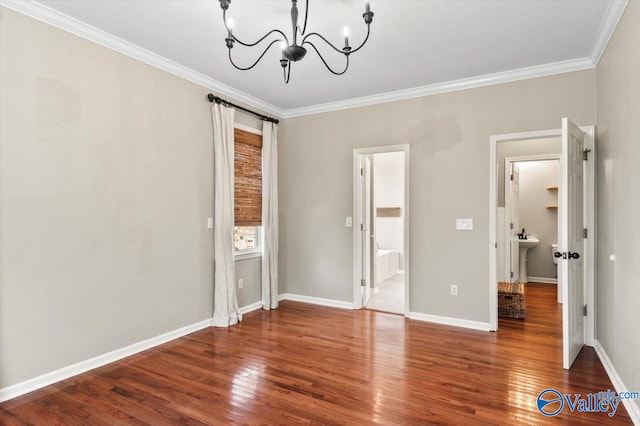 unfurnished bedroom with ensuite bath, sink, crown molding, a chandelier, and hardwood / wood-style flooring