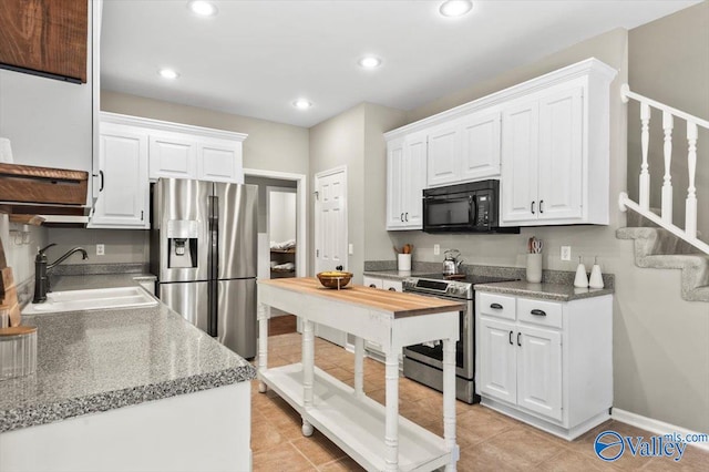 kitchen with white cabinetry, sink, light tile patterned floors, and stainless steel appliances