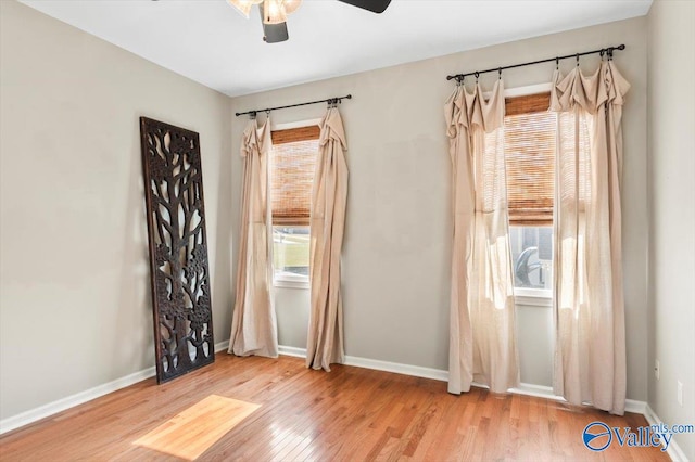 unfurnished room featuring plenty of natural light, ceiling fan, and light wood-type flooring