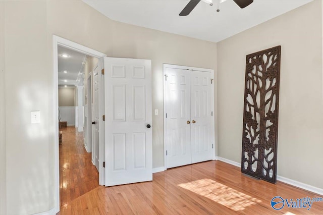 unfurnished bedroom featuring a closet, light hardwood / wood-style flooring, and ceiling fan