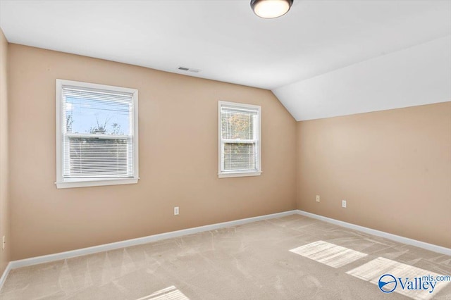 additional living space featuring light colored carpet and lofted ceiling