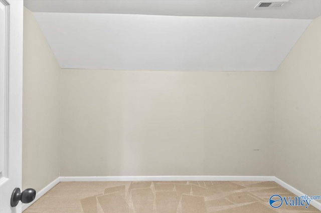 interior space with light colored carpet and vaulted ceiling