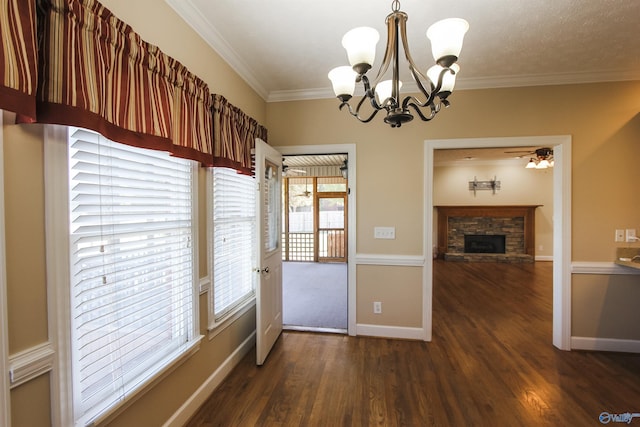 unfurnished dining area with a stone fireplace, dark hardwood / wood-style flooring, ceiling fan with notable chandelier, and ornamental molding