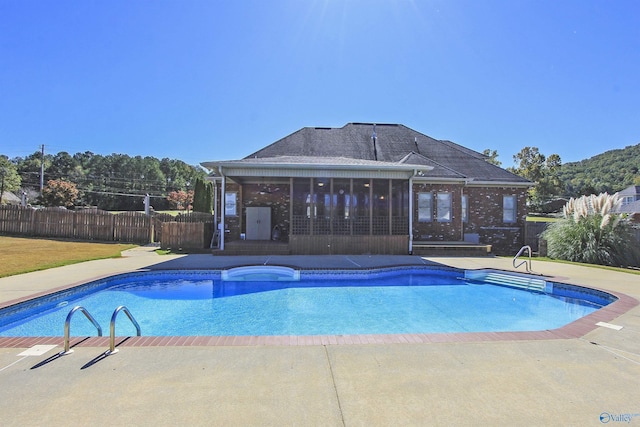 view of swimming pool featuring a patio area and a sunroom